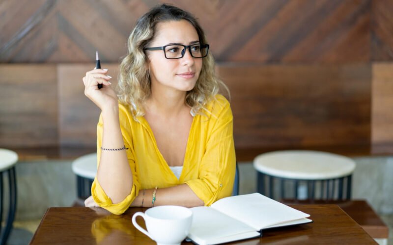 pretty-curly-young-woman-writing-notes-startup-project